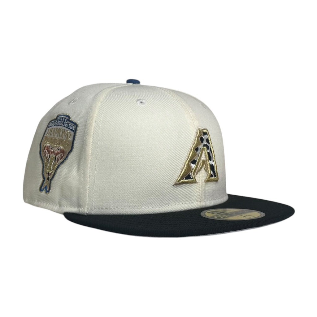 An off-white and black Arizona Diamondbacks fitted baseball cap featuring a gold and black 'A' logo on the front and a team patch on the side, set against a plain white background.