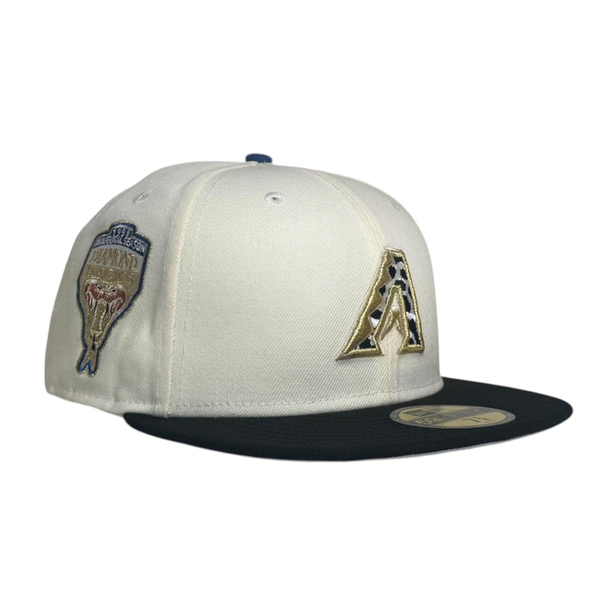 An off-white and black Arizona Diamondbacks fitted baseball cap featuring a gold and black 'A' logo on the front and a team patch on the side, set against a plain white background.